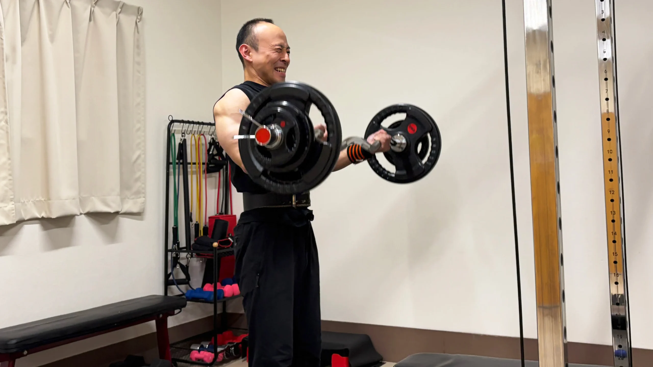 重たいダンベルで腕トレをしている男性